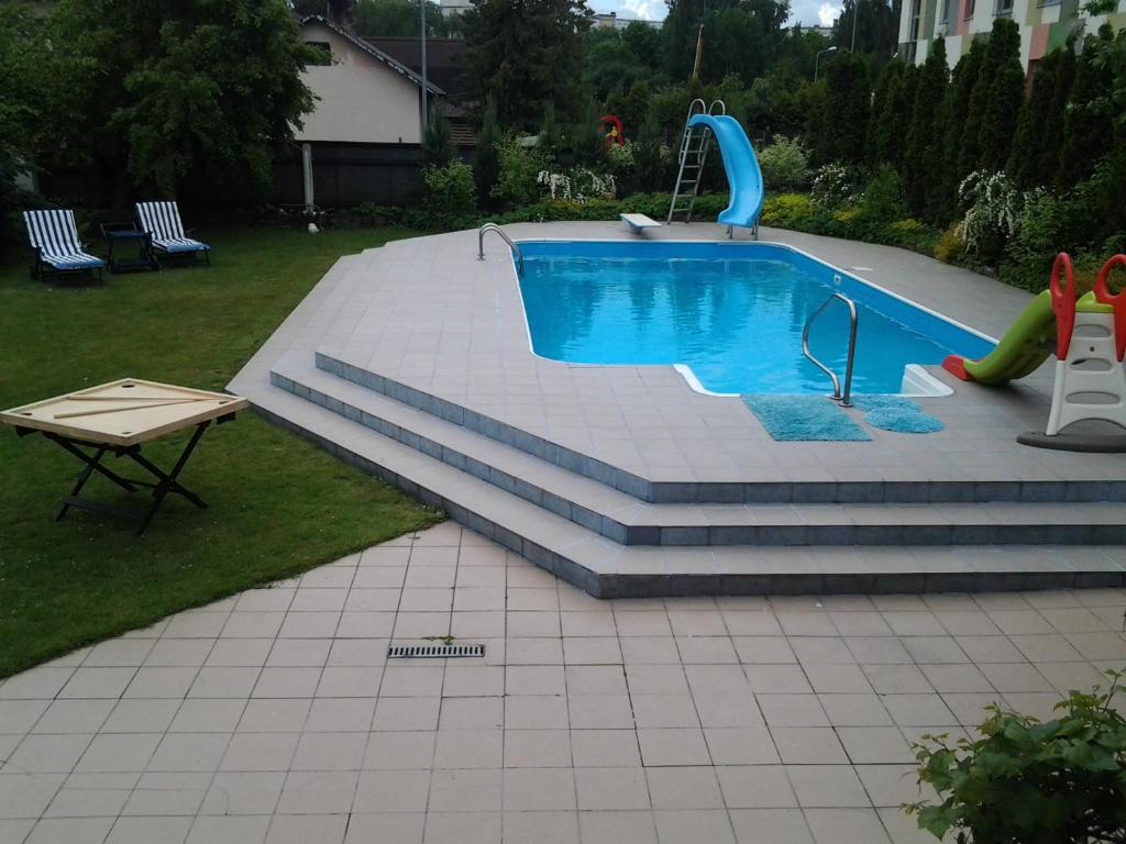 a swimming pool with a slide in a yard at Dolphin in Riga