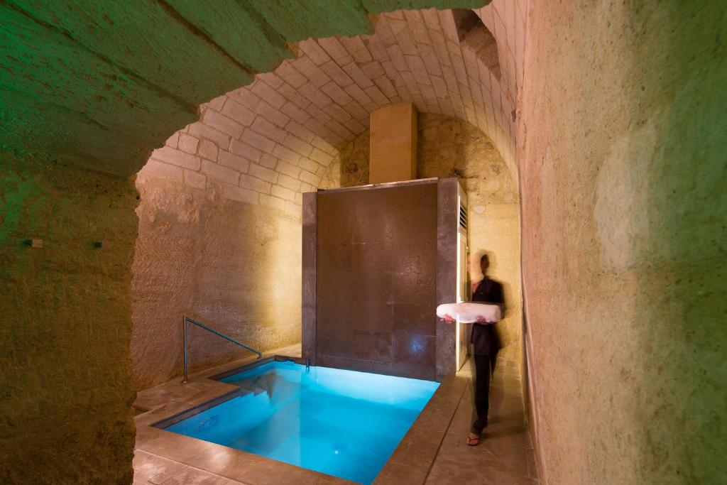 a person standing in a tunnel with a blue tub at La Maison d&#39;Uzès Relais &amp; Châteaux in Uzès