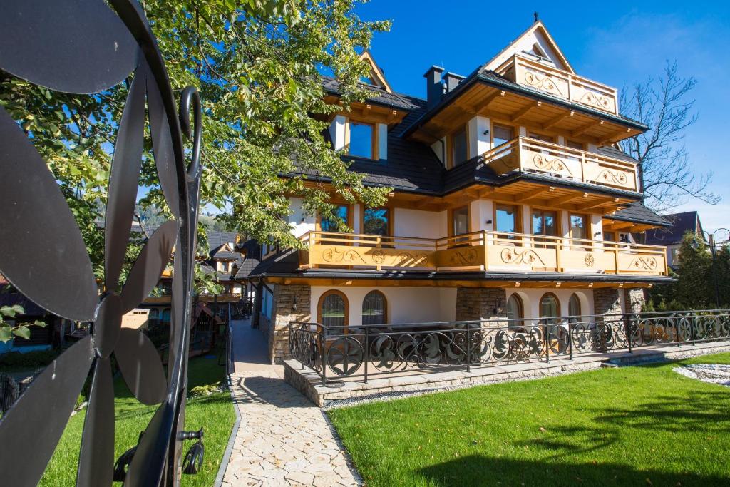 duży drewniany dom z balkonem w obiekcie Zakopiańskie Tarasy SPA Odkryj Zakopane w Zakopanem
