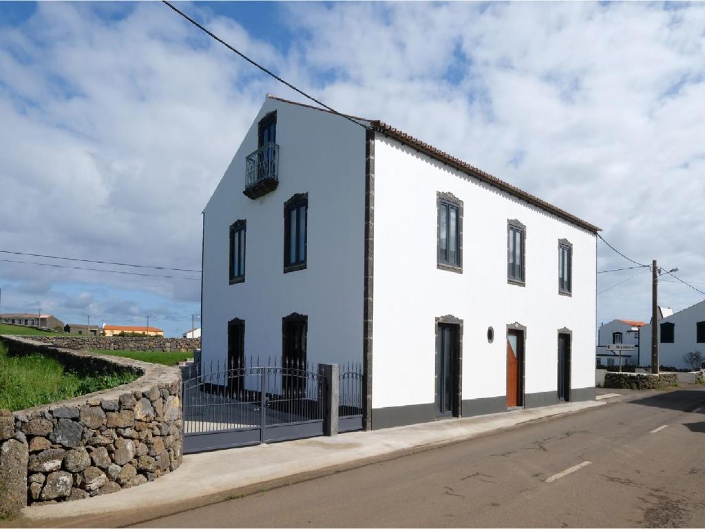 ein weißes Gebäude an der Straßenseite in der Unterkunft Casa Lagar de Pedra in Santa Cruz da Graciosa