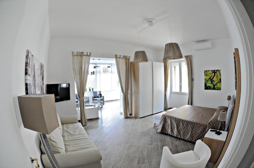 ein Schlafzimmer mit einem Bett und ein Wohnzimmer in der Unterkunft Maison Lumière in Salerno