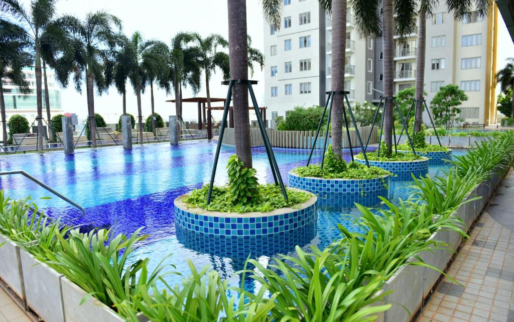- une piscine bordée de palmiers et un complexe dans l'établissement SkyLounge Apartment 2 Colombo, à Colombo