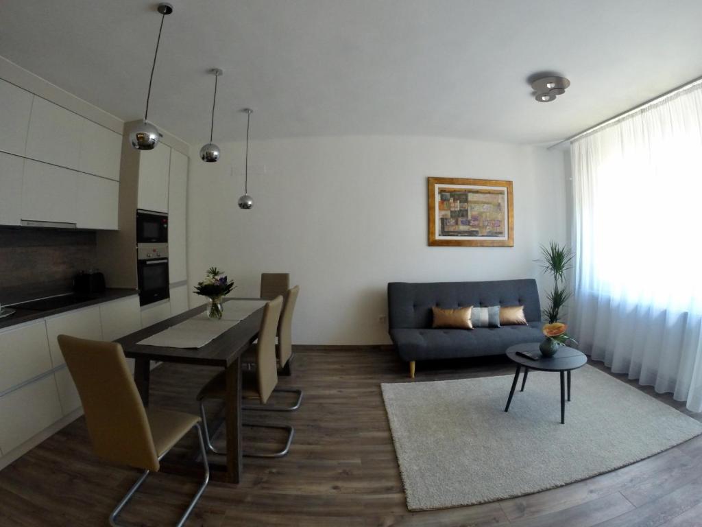 a living room with a table and a blue couch at Heroes' Residence in Budapest