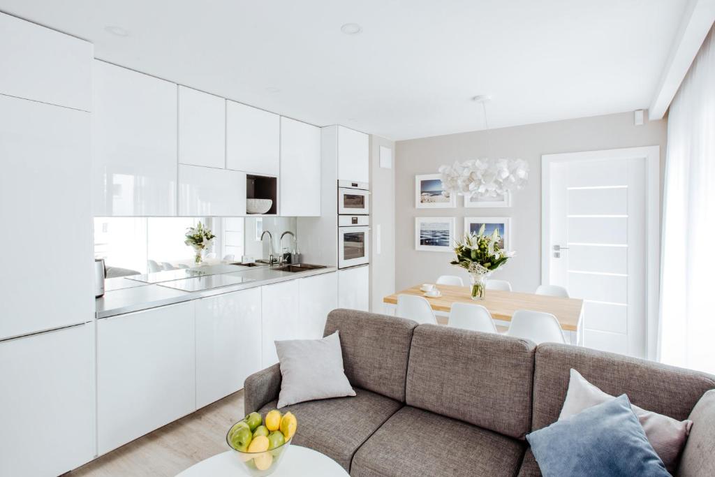kuchnia i salon z kanapą i stołem w obiekcie Apartment No. 1 - Vento Apartamenty we Władysławowie