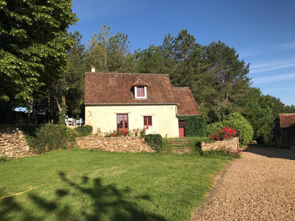 een huis met een stenen muur en een tuin bij Gîte De Serre in Le Grand-Pressigny