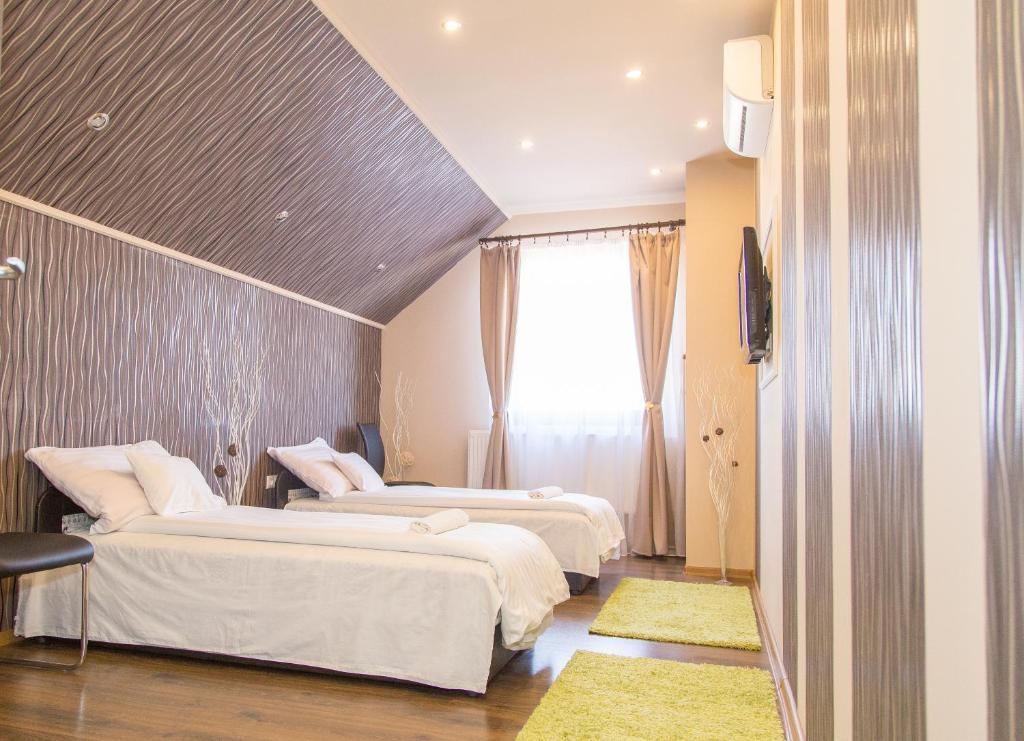 ein Hotelzimmer mit 3 Betten und einem Fenster in der Unterkunft Cantry Ételbár in Balkány