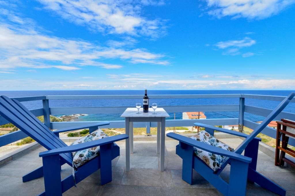 einen Tisch und Stühle auf einem Balkon mit Meerblick in der Unterkunft Kimothoy in Armenistis