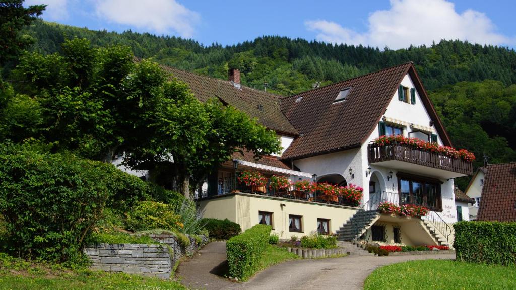 ein großes weißes Haus mit Blumen auf dem Balkon in der Unterkunft Landgasthof Grüner Baum in Badenweiler