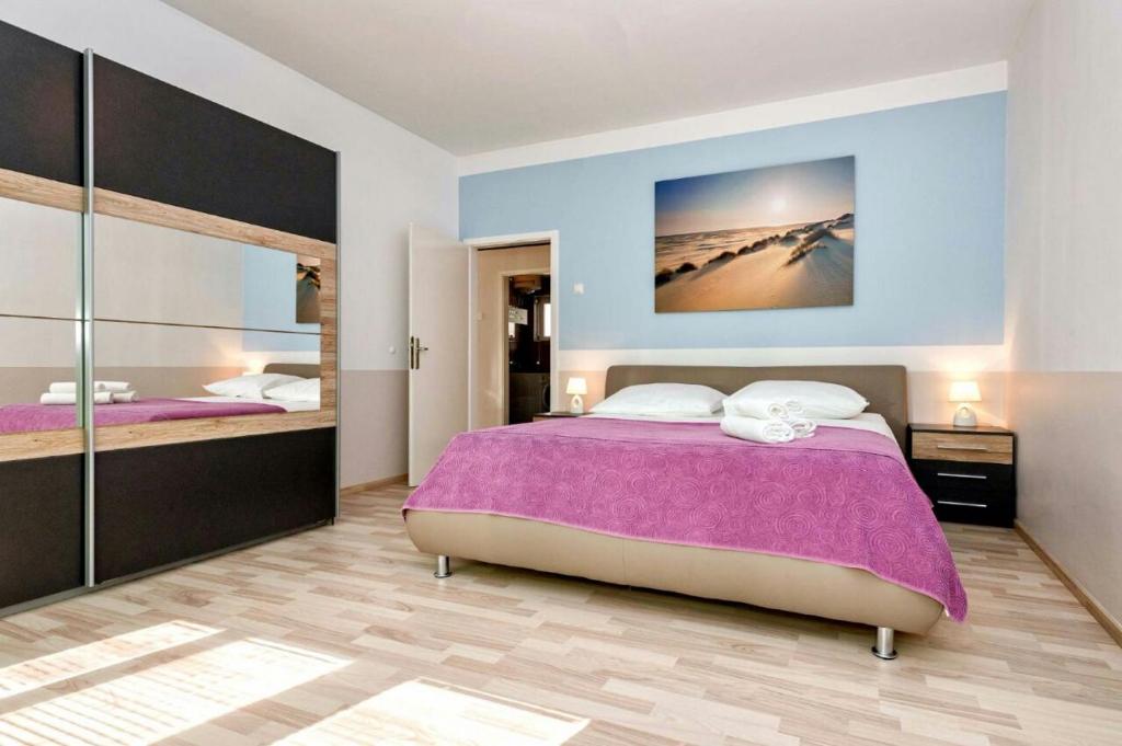 - une chambre avec un grand lit et un grand miroir dans l'établissement Apartment Maja, à Split