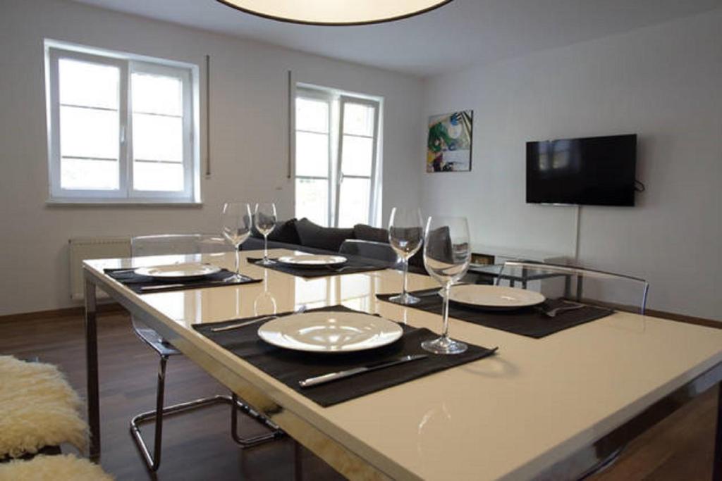 una sala de estar con una mesa con platos y copas de vino en Traumwohnung am Altstadtrand, en Regensburg