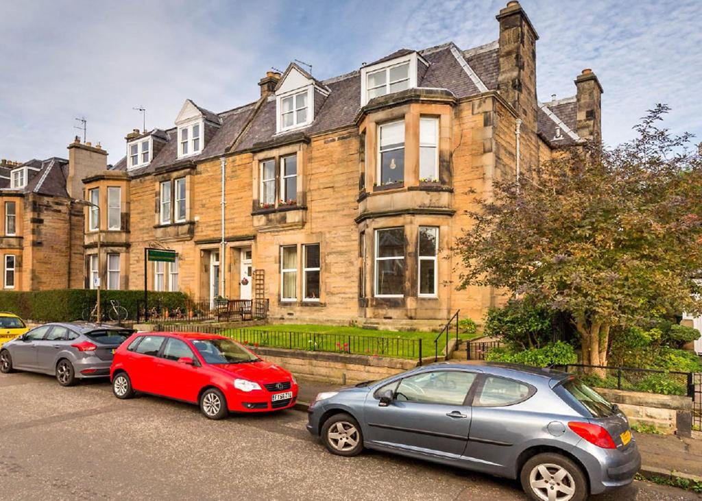 three cars parked in front of a large building at Airdenair Guest House in Edinburgh