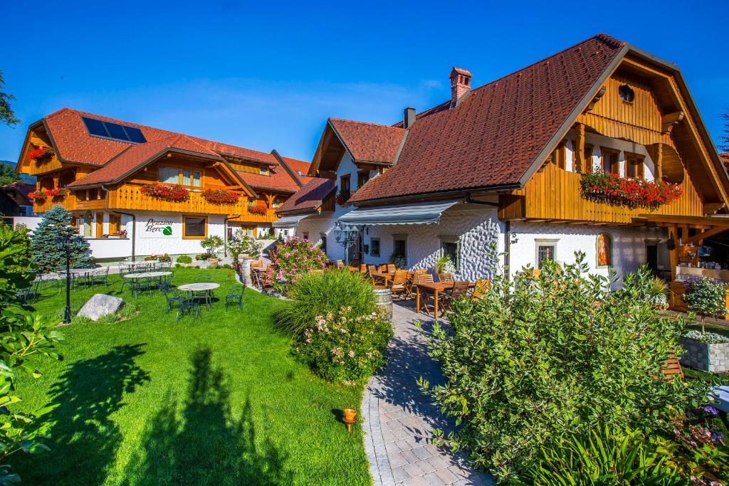 una casa con un patio con mesas y sillas en Penzion Berc en Bled