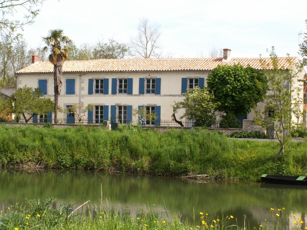 une vieille maison avec une rivière devant elle dans l'établissement La Balangere, à Coulon