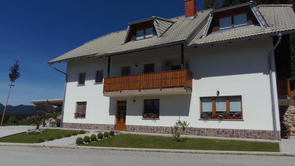ein weißes Haus mit einem Balkon an der Seite in der Unterkunft TURISTIČNA KMETIJA STREVC in Solčava