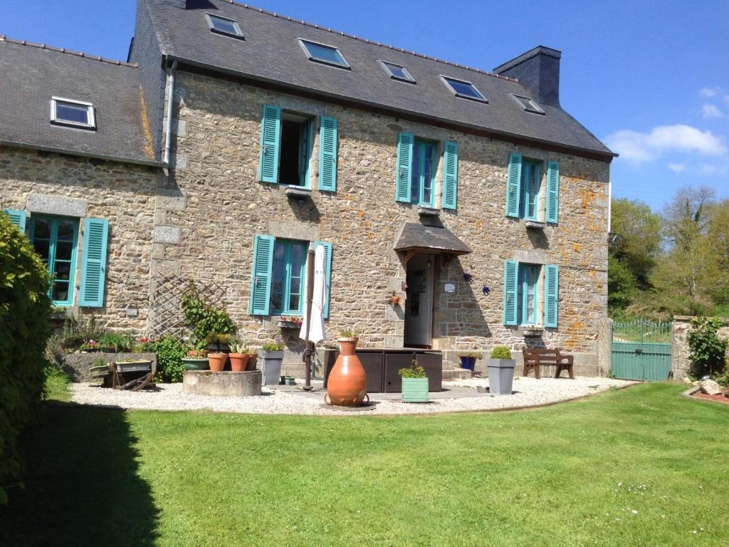 a large stone house with green shutters and a yard at Ty Gwennili in Kérien