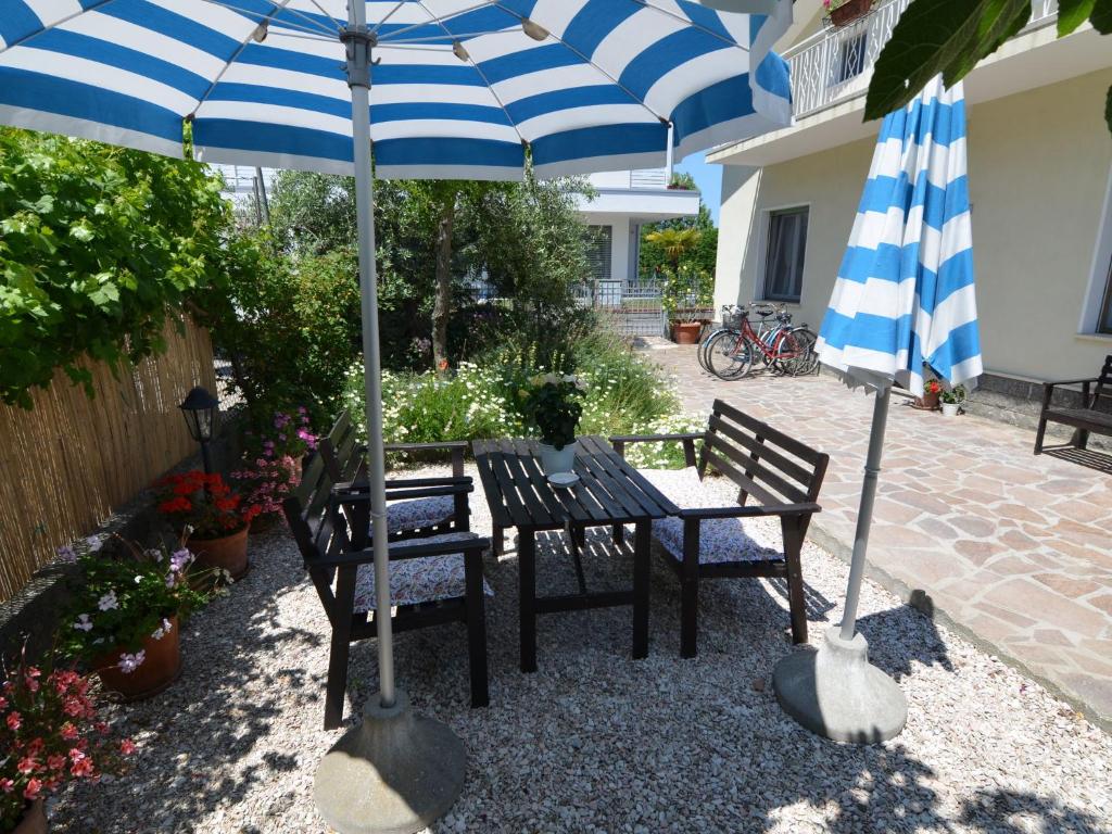 ガッテーオ・ア・マーレにあるBelvilla by OYO Venturi Oliveの青と白の傘下のテーブルと椅子