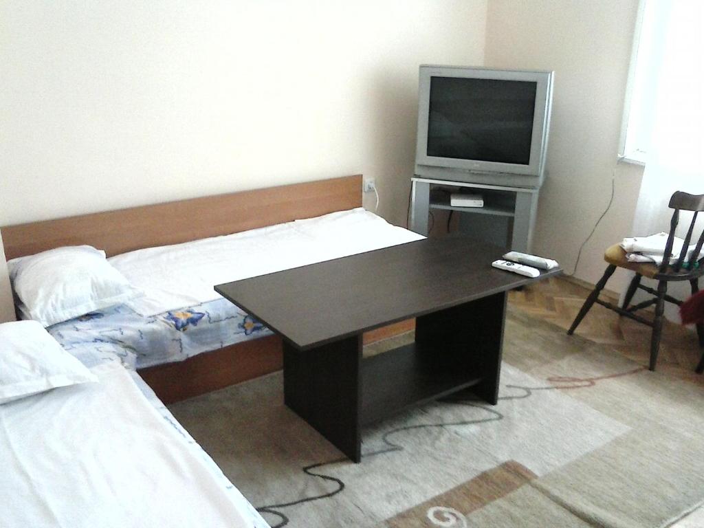 ヴァルナ・シティにあるApartment Dimitrovのデスク、テレビ、ベッドが備わる客室です。