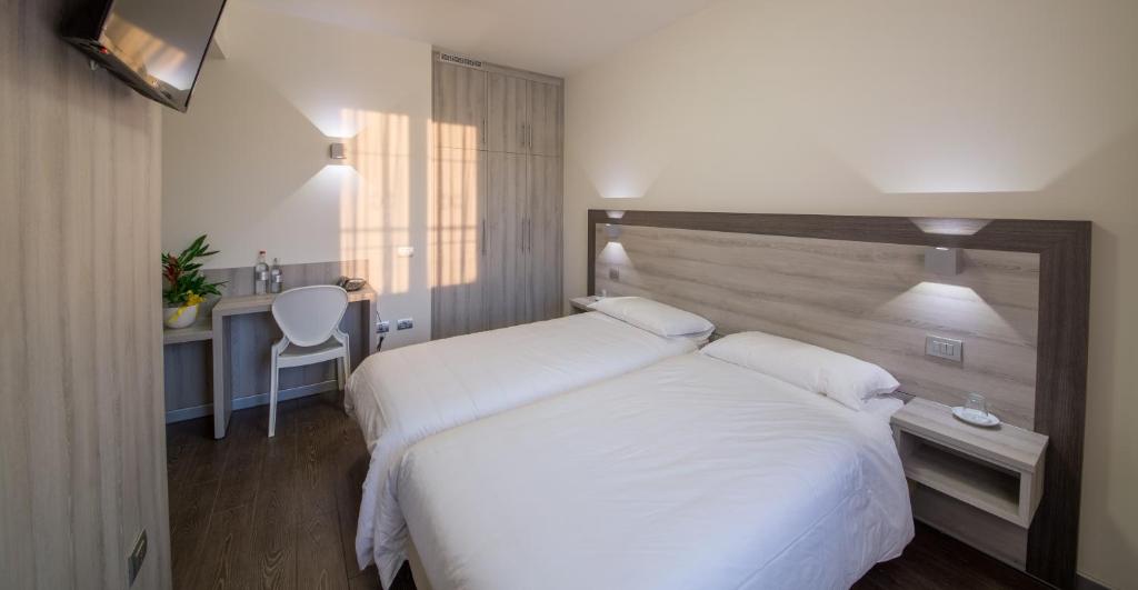 ブレシアにあるHotel Colombera Rossaのベッドルーム(白いシーツを使用した大型ベッド1台付)