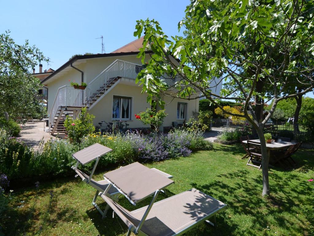 einen Garten mit zwei Stühlen, einem Tisch und einem Haus in der Unterkunft Belvilla by OYO Venturi Lemon in Gatteo a Mare