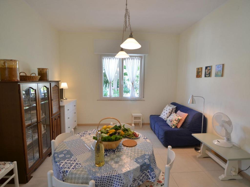 salon ze stołem i niebieską kanapą w obiekcie Apartment in Gatteo near Adriatic Beach w mieście Gatteo a Mare