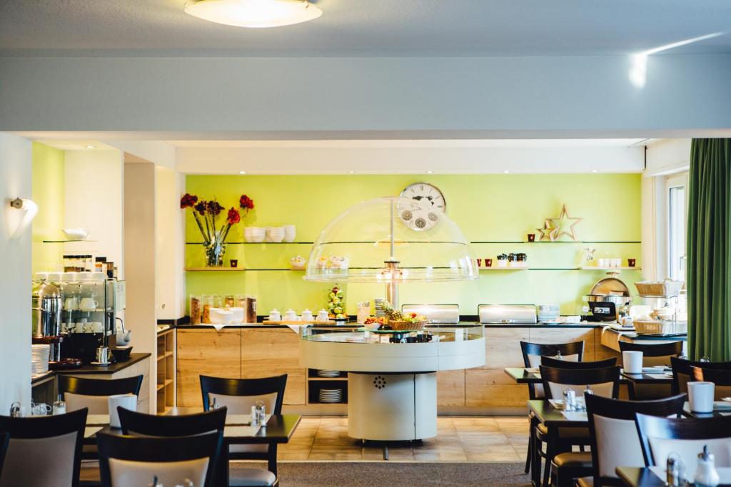 a restaurant with yellow walls and tables and chairs at Hotel Astoria Bonn in Bonn