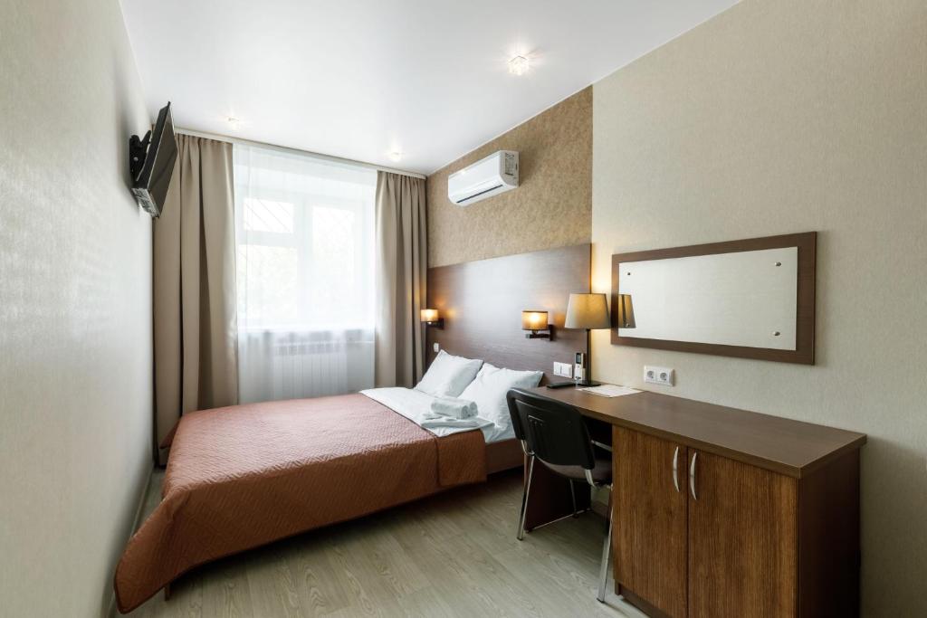 ケメロヴォにあるАвионのベッドとデスクが備わるホテルルームです。