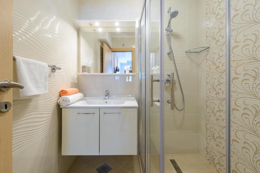 米利尼的住宿－Villa Ive，浴室配有白色水槽和淋浴。