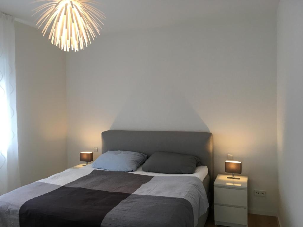 Un dormitorio con una cama grande y una lámpara de araña. en Apartment unter den Weinbergen en Königswinter