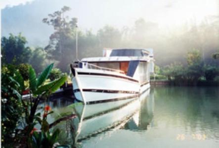 a boat is docked in the water on a lake at Sailor's Rest in Kampung Janda Baik