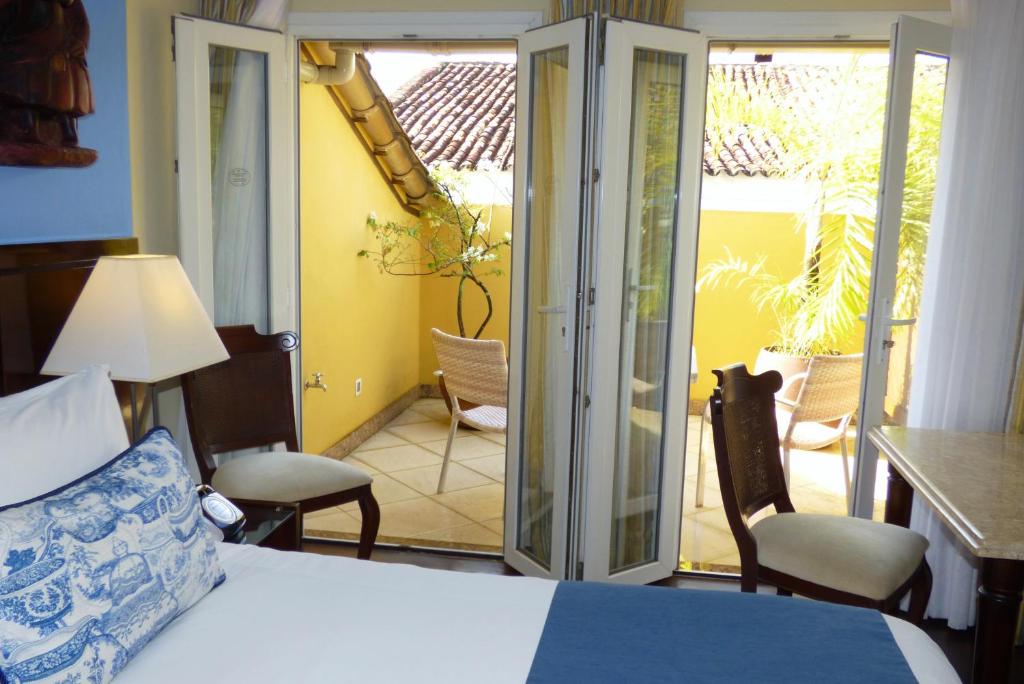 a bedroom with a bed and a sliding glass door at Hotel Casa do Amarelindo in Salvador