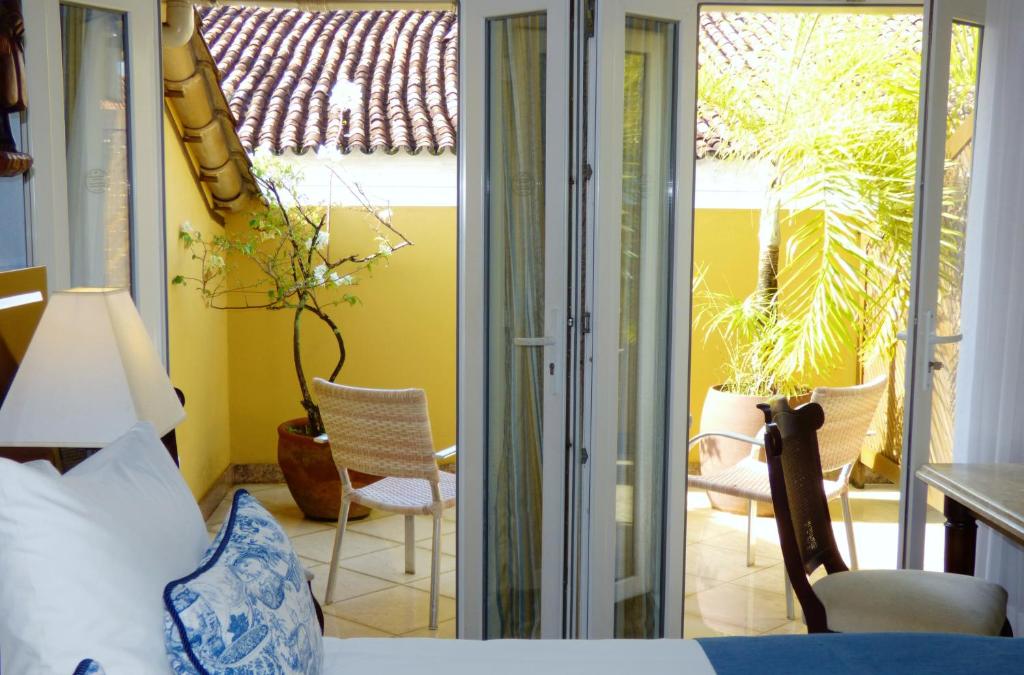 a bedroom with a bed and sliding glass doors at Hotel Casa do Amarelindo in Salvador