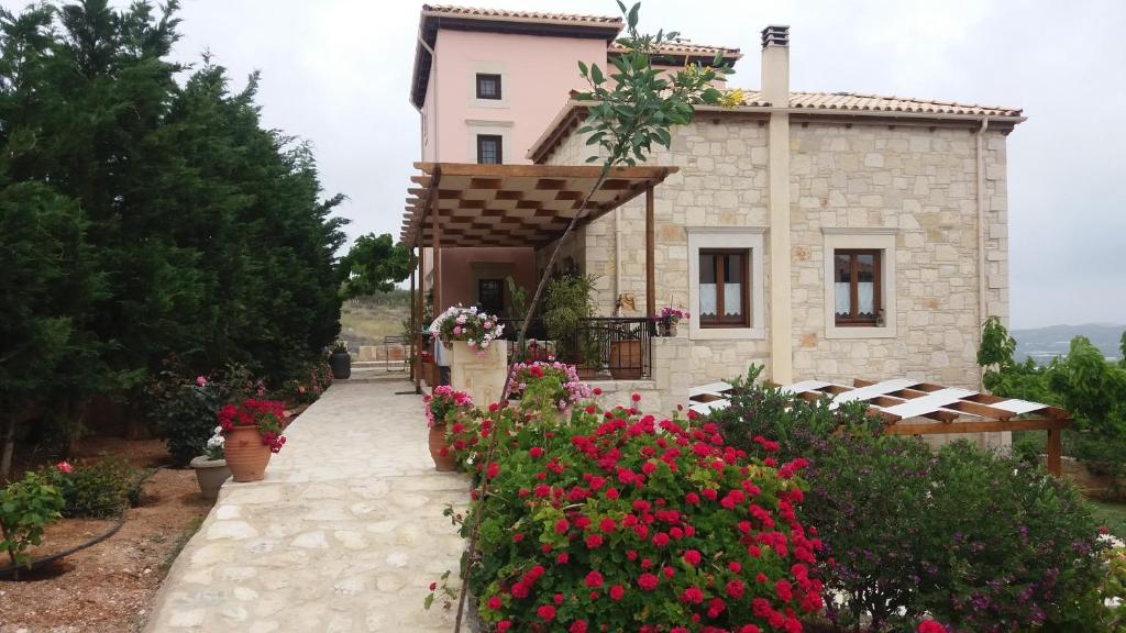 une maison avec des fleurs devant elle dans l'établissement Kritamos Villa & Apartments, à Kamilárion