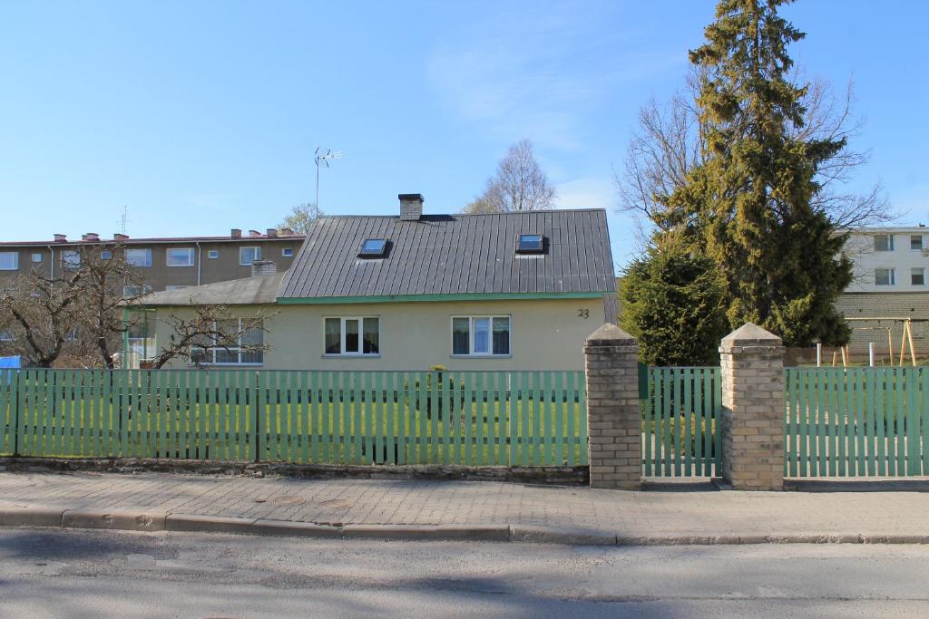 a green fence in front of a house at Posti Holiday Home in Rakvere