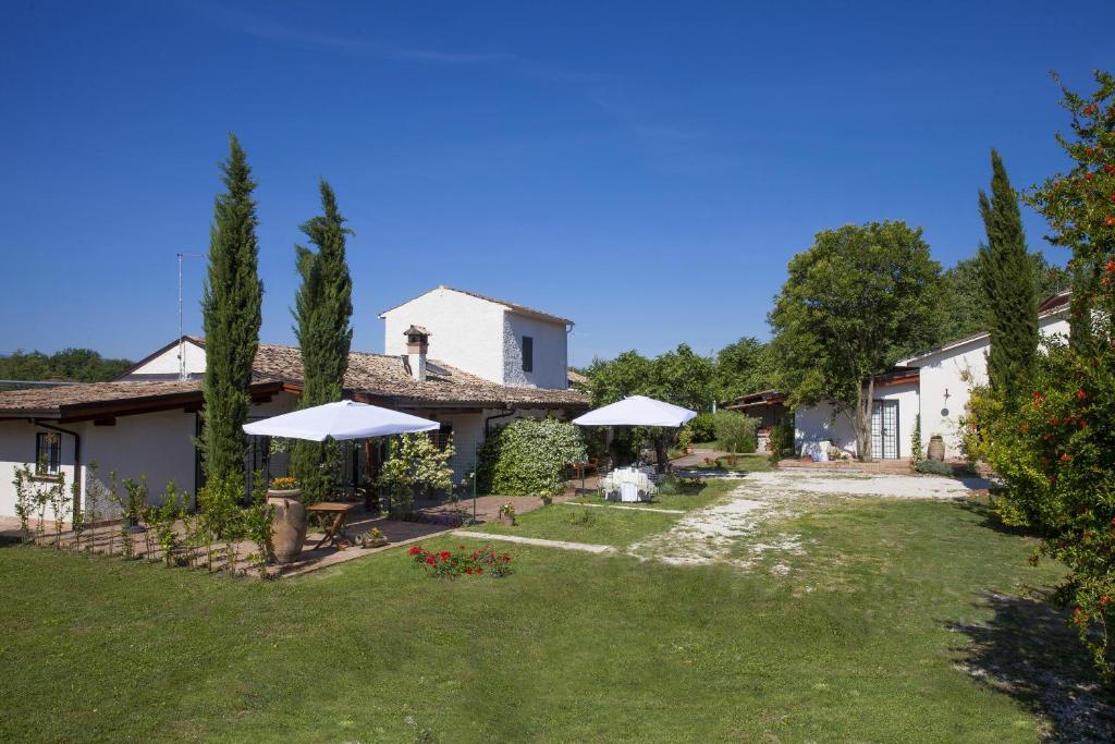 una casa con un patio con árboles y sombrillas en Antico Casale Spezia Pelagalli, en Aquino