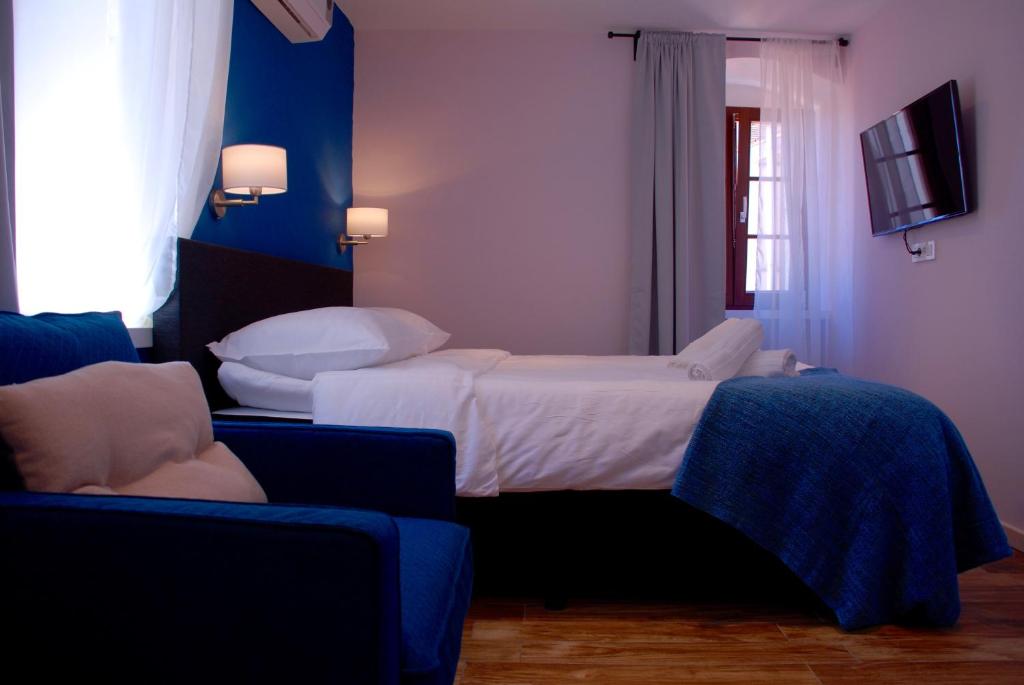 um quarto com uma cama, uma televisão e um sofá em Old Town Inn em Rijeka