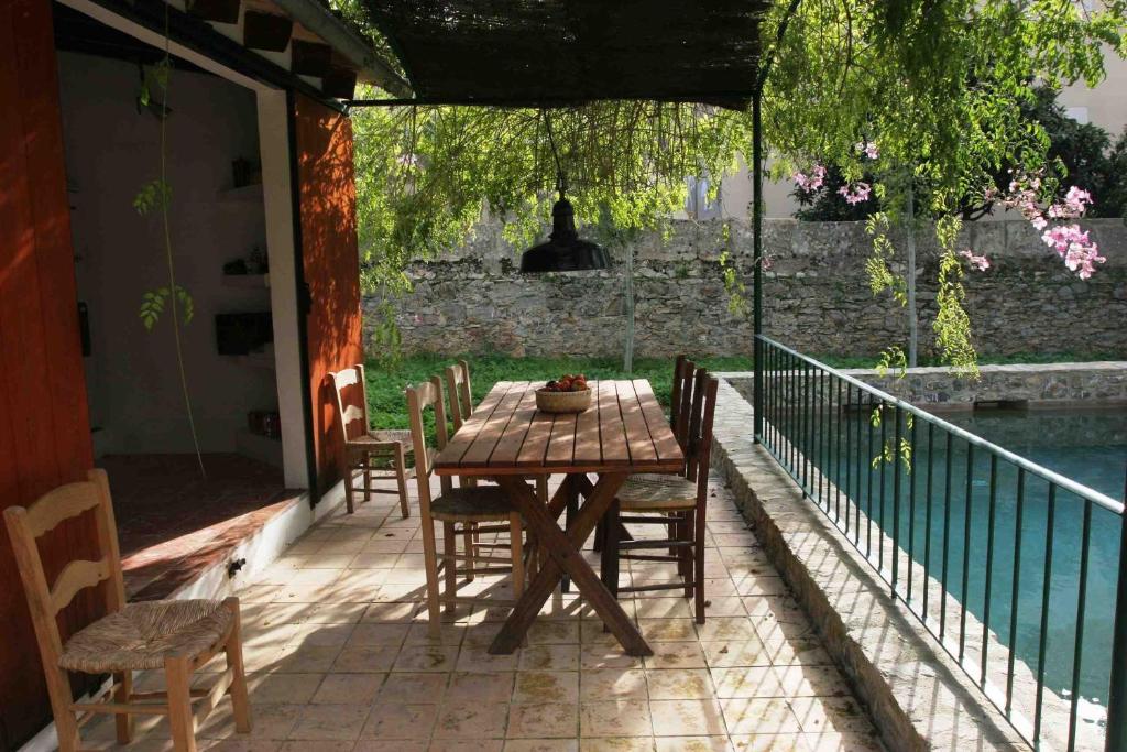 アルタにあるCas Canonge Villa con jardín y piscinaの木製テーブルと椅子付きのパティオ