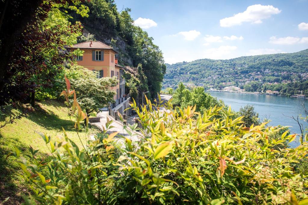 een huis op een heuvel naast een rivier bij La Dolce Vita - The House Of Travelers in Como