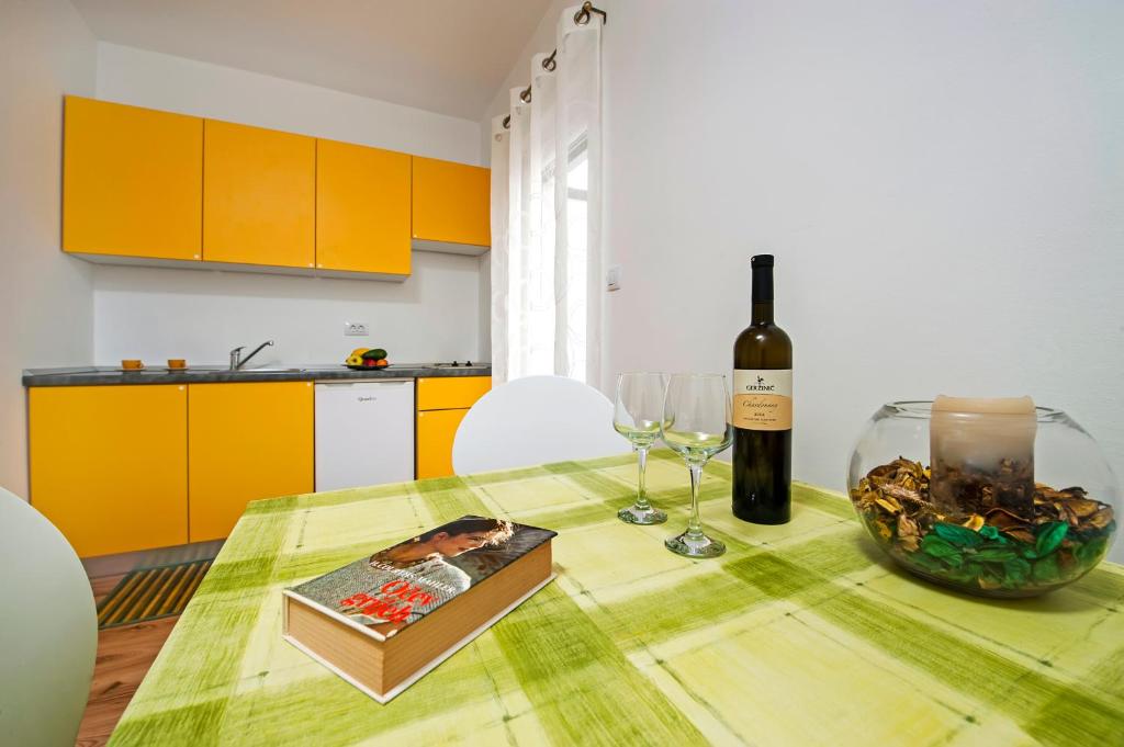 a dining room table with a bottle of wine and a wine glass at Apartments Roko in Rovinj