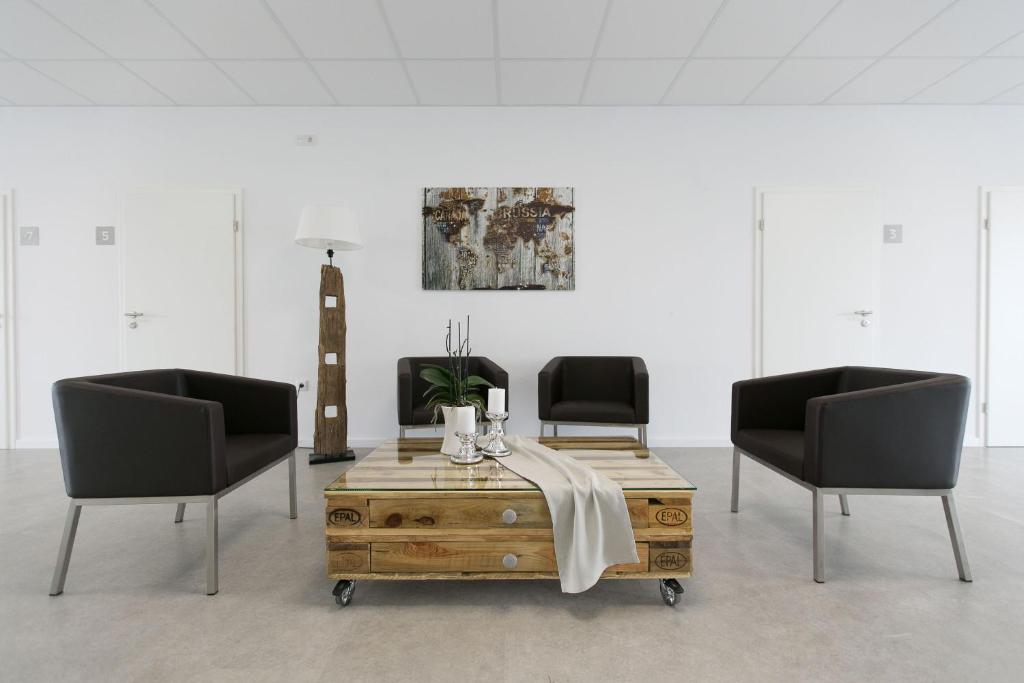 salon z 2 krzesłami i stołem ze stołem w obiekcie Zimmervermietung Reichert w mieście Lage
