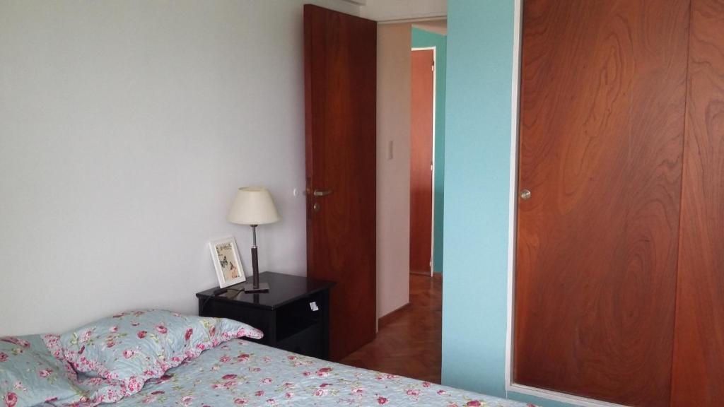 a bedroom with a bed and a wooden door at Departamento Vicente Lopez sobre Av Maipu in Vicente López