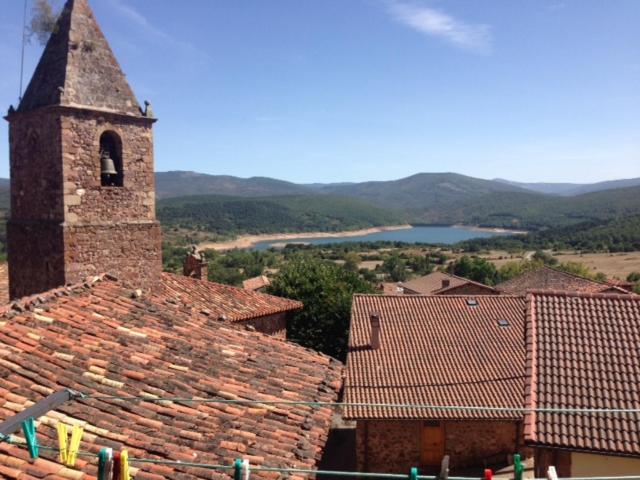 un campanario de iglesia y techos de una ciudad con un lago en Apartamento Turísticos Luar 3, en El Rasillo