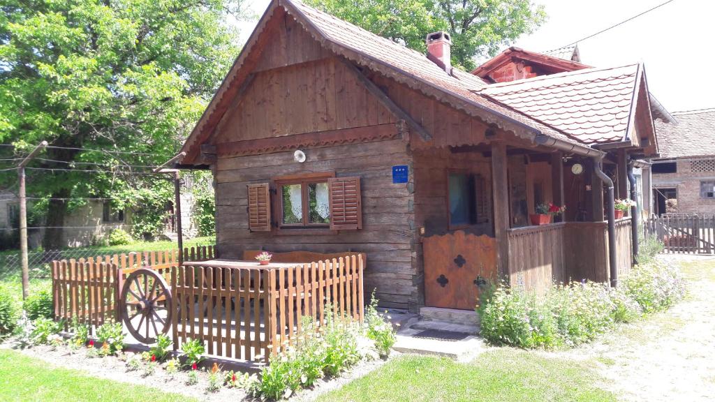 ein kleines Holzhaus mit einem Rad im Hof in der Unterkunft Apartments Kuvarna in Čigoč