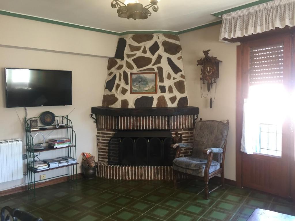 sala de estar con chimenea y TV en Apartamentos Turísticos Luar II, en El Rasillo