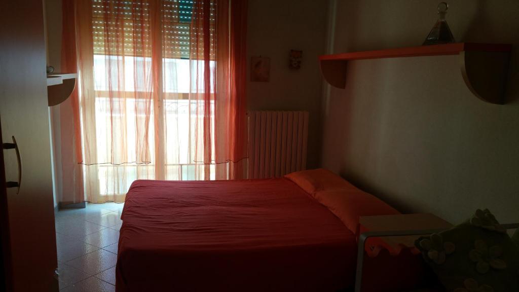 ナルドにあるappartamento intero Venusのベッドルーム1室(赤いベッド1台、窓付)