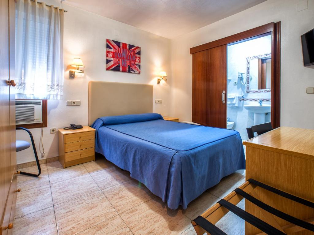 a bedroom with a blue bed and a desk at Hotel Legazpi in Murcia