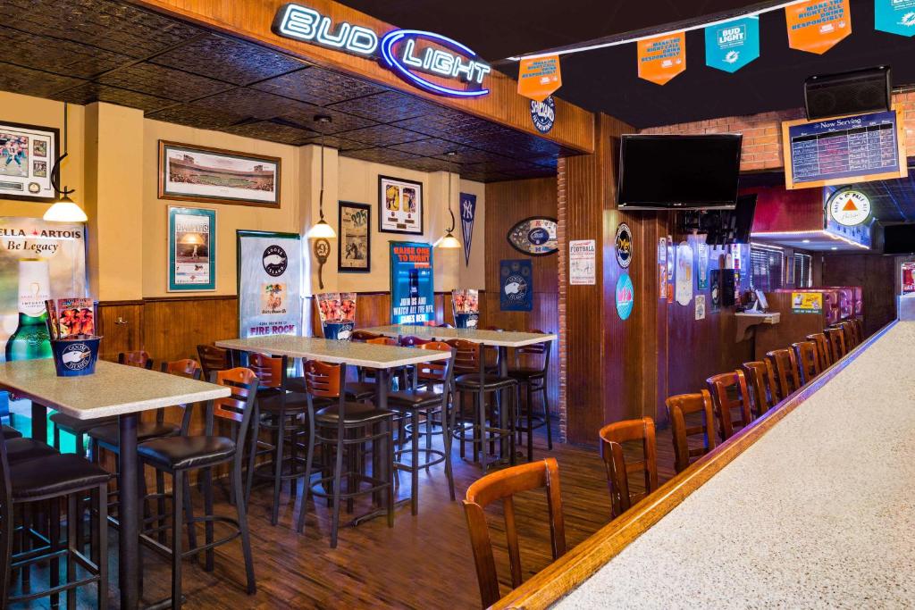 a bar with tables and chairs in a restaurant at Ramada by Wyndham Miami Springs/Miami International Airport in Miami