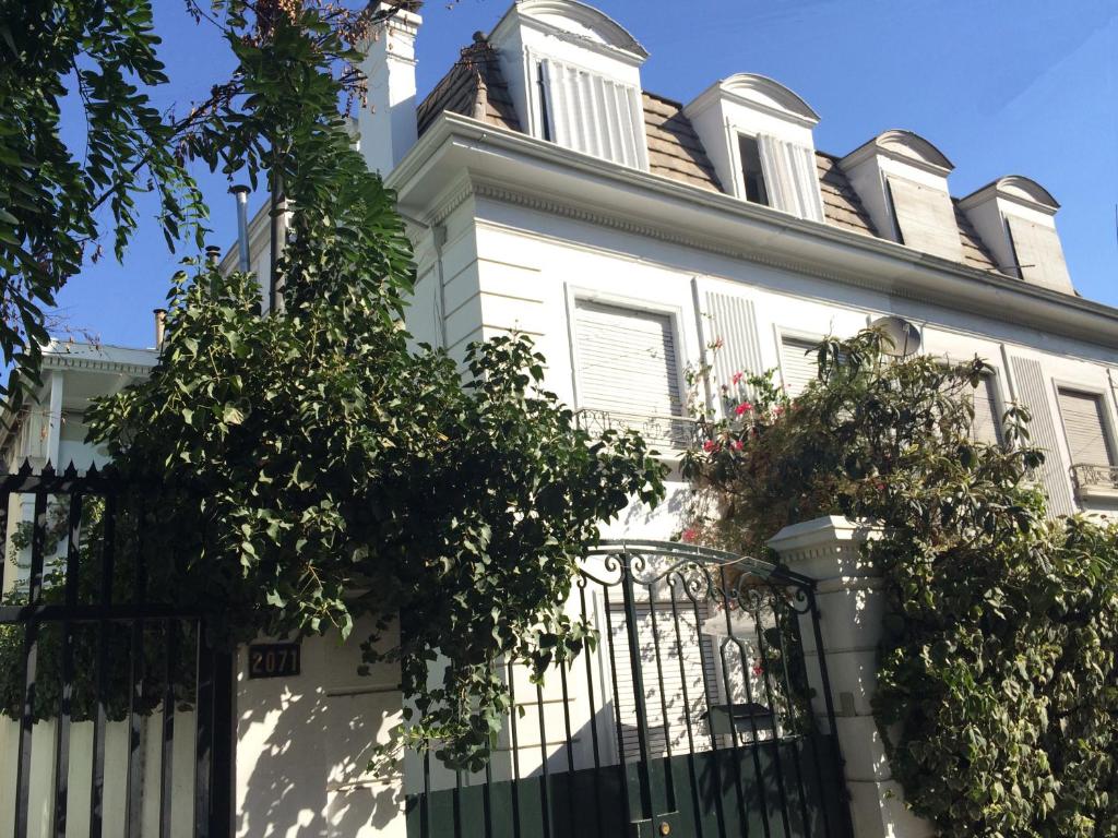 a white house with a gate and flowers at Linda casa para grupos / familias in Santiago