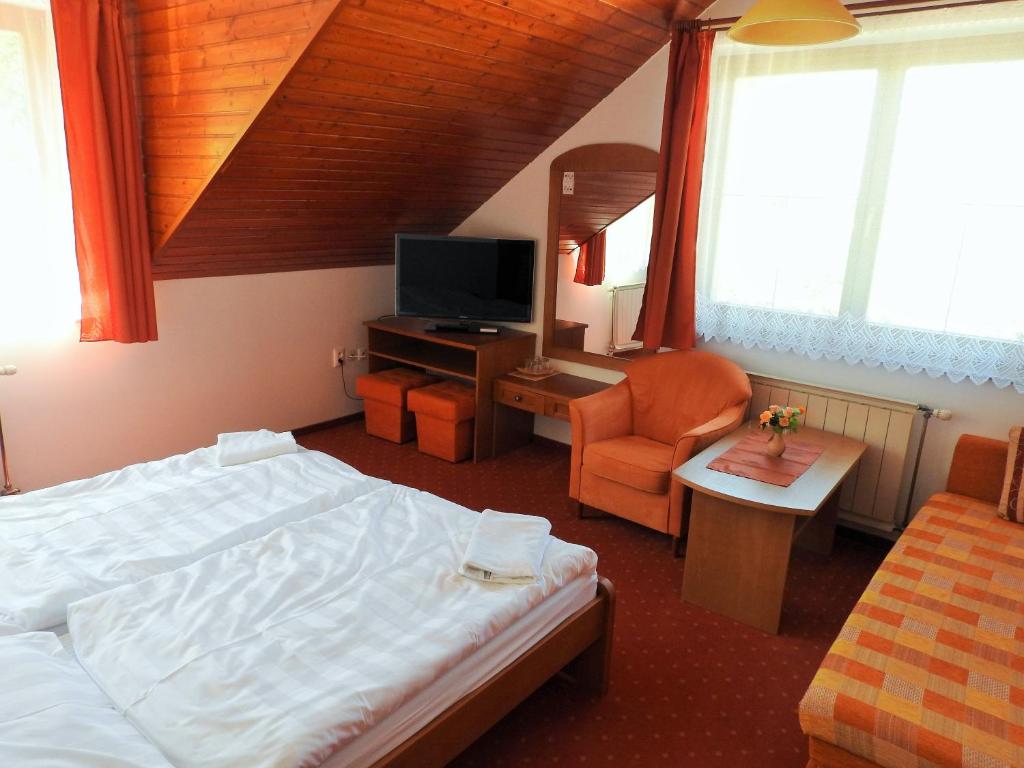 A bed or beds in a room at Penzion Montana