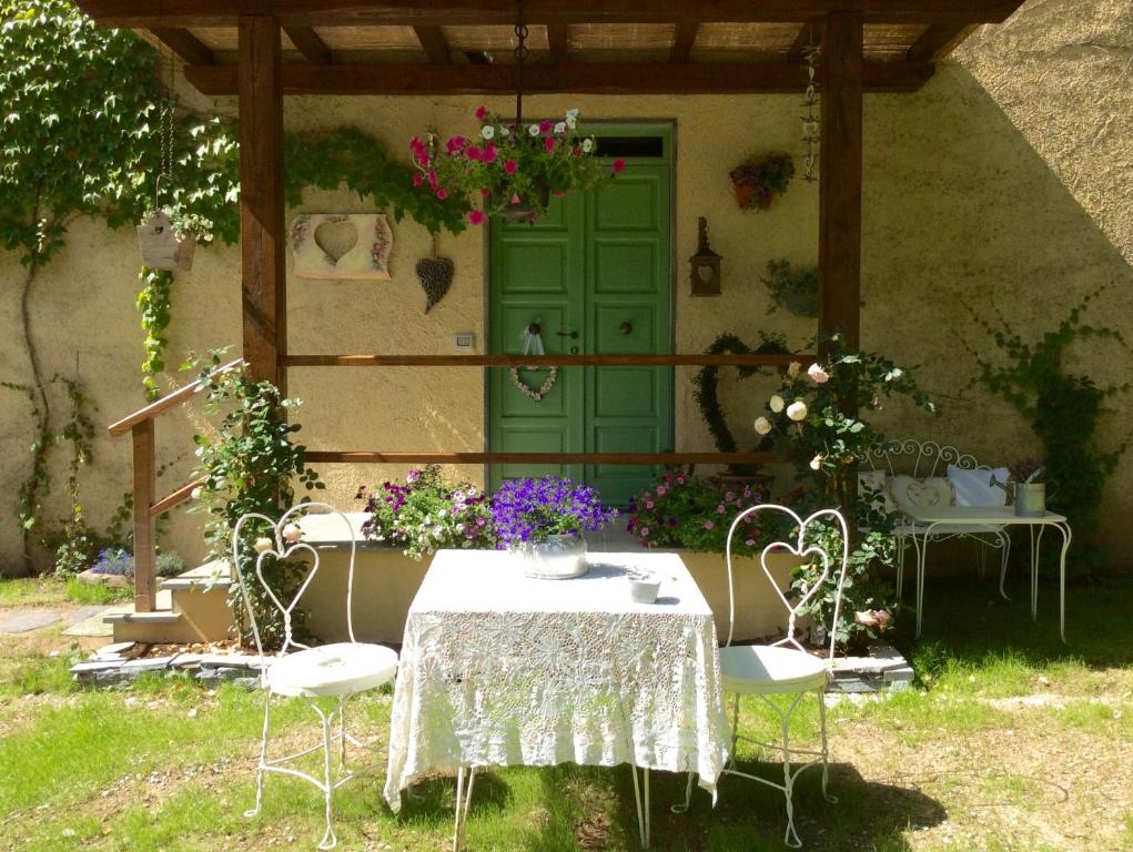 a table and chairs in front of a house with a green door at La casa del cuore in Stazzema