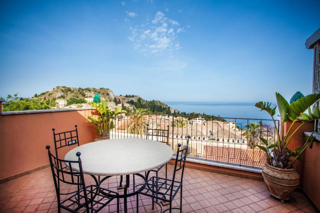 タオルミーナにあるCasa Carlaのテーブルと椅子、海の景色を望むバルコニー